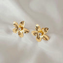 Brinco Flor metalizada com zircônia no meio, pressão, banhada a ouro, medindo 2,5cm.