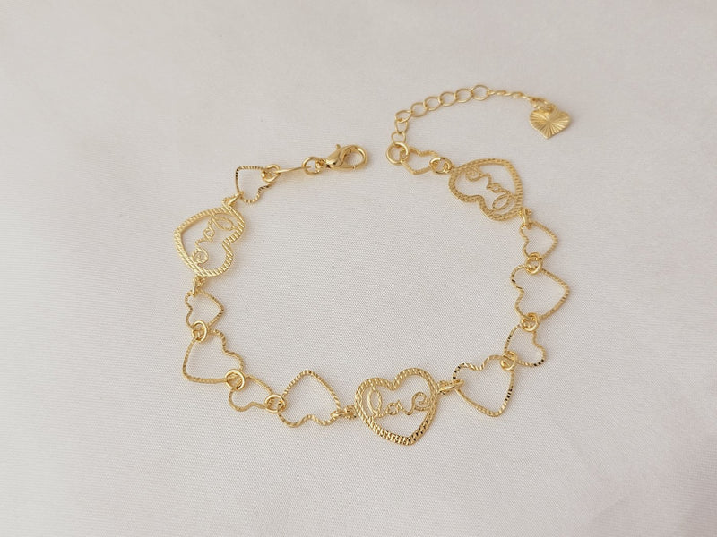 Pulseira de coração vazado e coração escrito love, banhado a ouro, medindo 21cm com extensor.